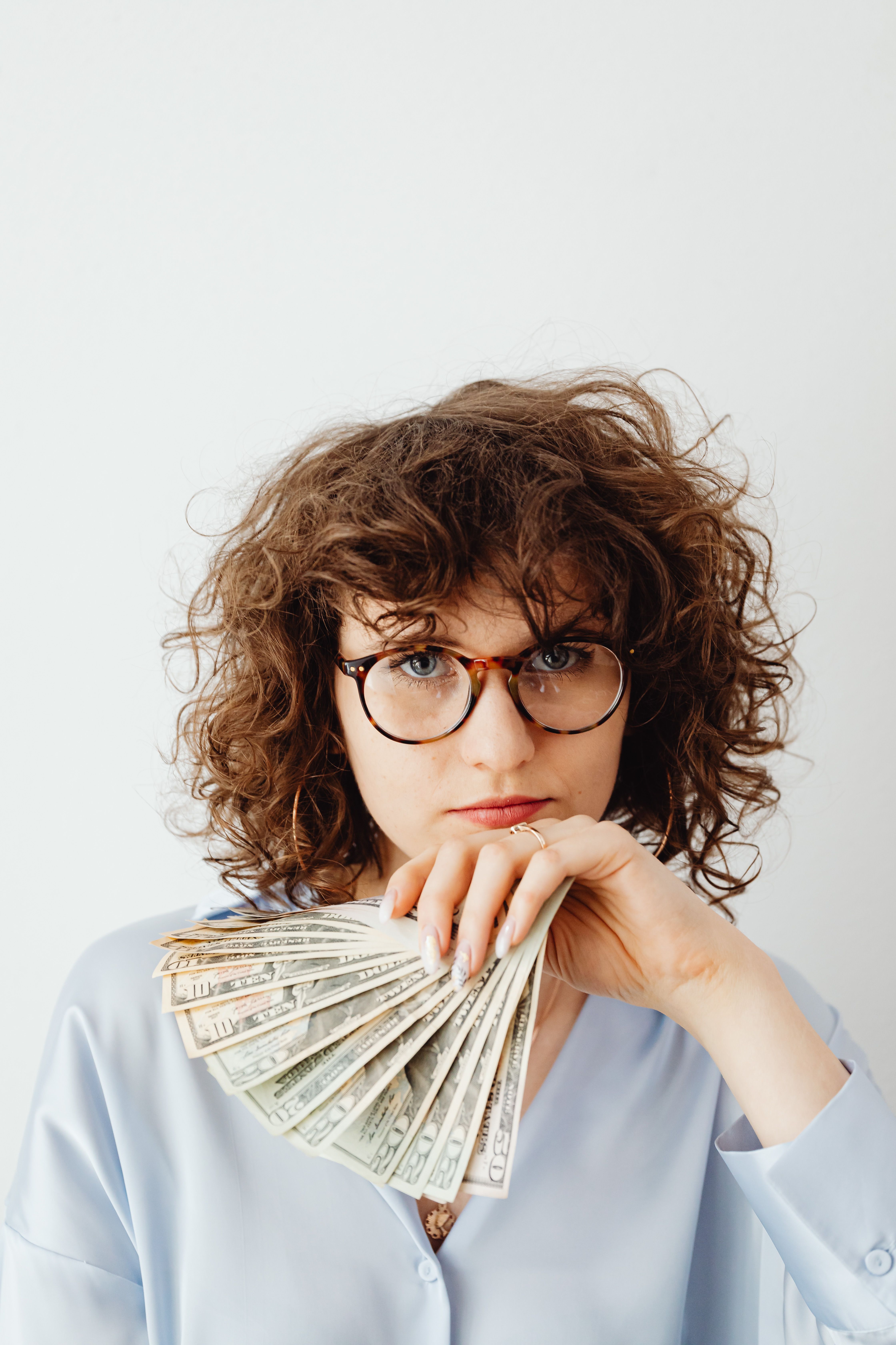A person holding a fan of cash, for extra cash from becoming an affiliate
