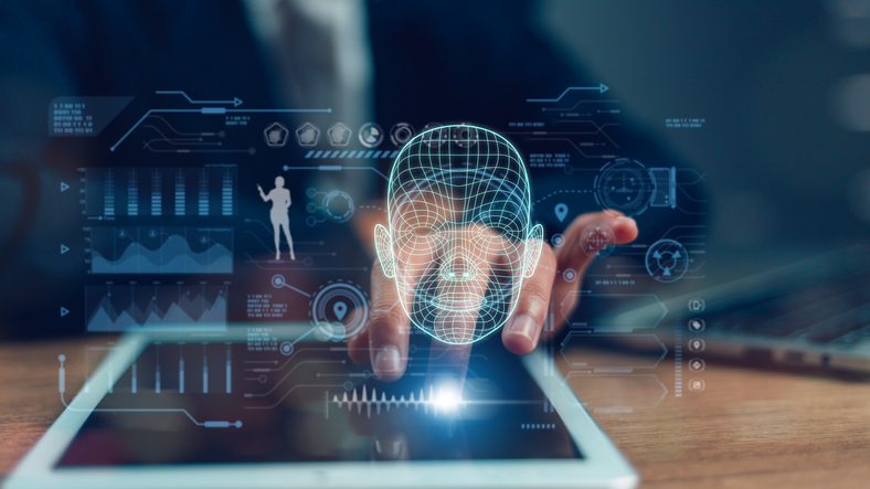 A glowing wireframe digital head floating above a tablet, representing an impersonated identity